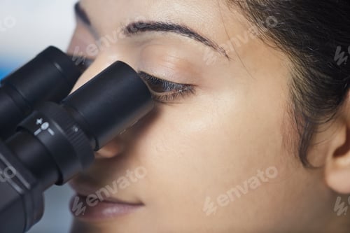 Preview: Young Woman Using Microscope in Laboratory Setting