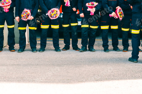 Preview: Group of firefighters with bouquets to give to their partners in a tribute.