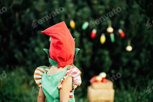 Preview: Child waiting for a Christmas in wood in july. portrait of little children near christmas tree.