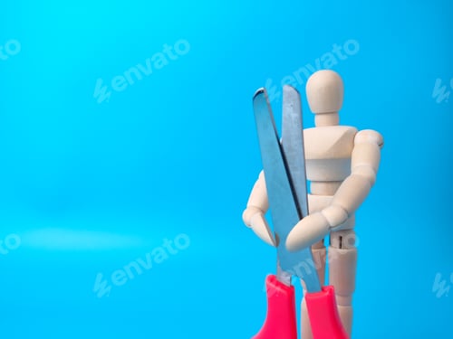 Preview: Wooden mannequin holding red scissors on a blue background with copy space.