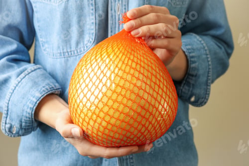 Preview: Woman hold ripe pomelo fruit, close up