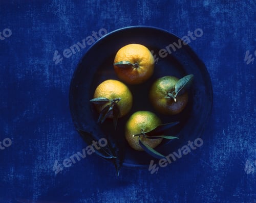 Preview: Overhead view of green oranges on pewter plate