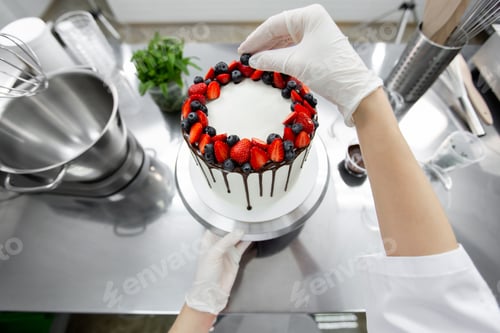 Preview: Pastry chef decorates the cake with chocolate streaks of strawberries and blueberries