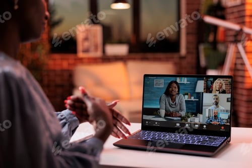 Preview: Businesswoman chatting with coworkers online using videocall software