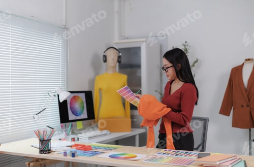 Preview: Fashion designer working with colour swatches and choosing colour for new clothes collection