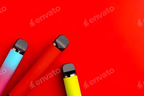 Preview: Disposable electronic cigarettes on red background close up