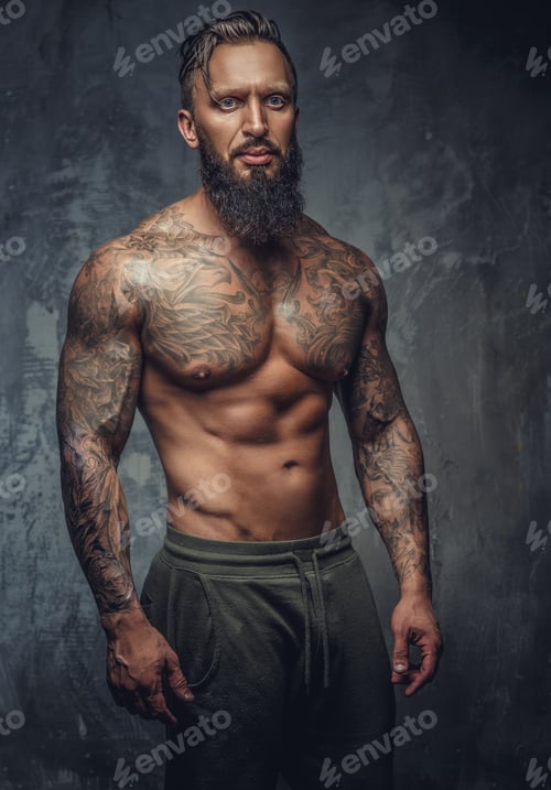 Preview: Tattooed muscular man with beard in stripes panties.