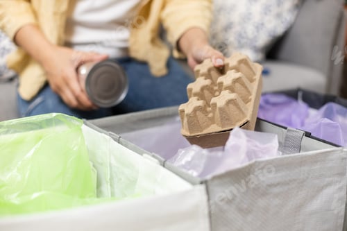 Preview: Female sitting at home separating paper and plastic waste. Garbage sorting for recycle.