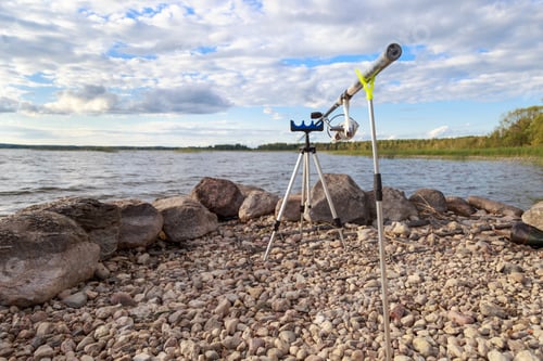 Preview: The fishing rod is set on the shore of the lake. There are no people in the photo