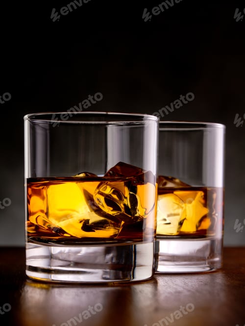 Two Glasses of Whiskey with Ice on Table