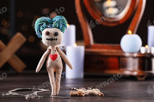 Preview: Female voodoo doll with pins in heart and ceremonial items on wooden table, space for text