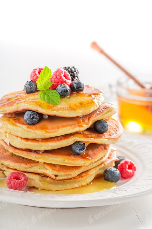Preview: American pancakes served with honey and berries. Pancakes for breakfast.