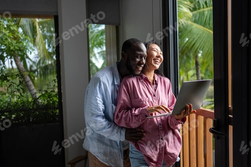 Preview: Multicultural couple working remotely, planning finances and investments online. Digital lifestyle