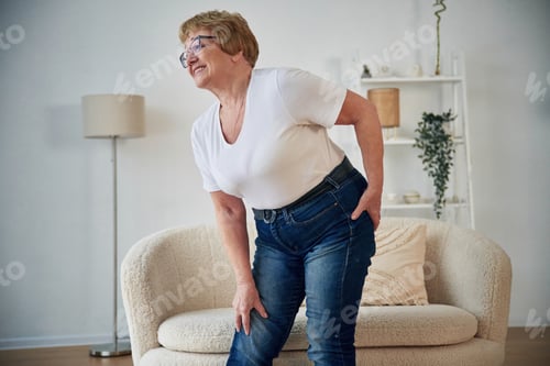 Preview: Pain in the leg. Senior elderly woman is at home in the living room