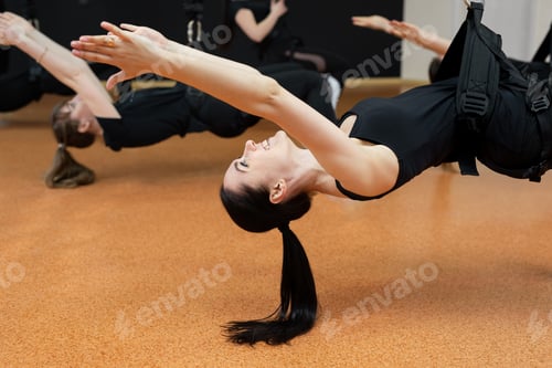 Preview: Close-up group of girls hanging on bungee rubber bands in the gym.