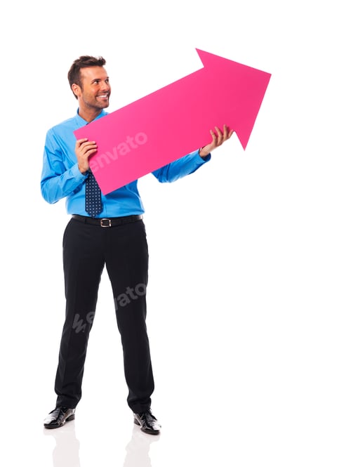 Preview: Handsome business man holding pink arrow and pointing at copy space
