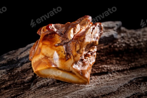 Preview: Natural amber. A piece of brownish opaque natural amber on white background