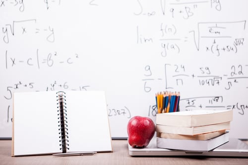 Preview: Books, notebook and pencils on table with a blurred white board