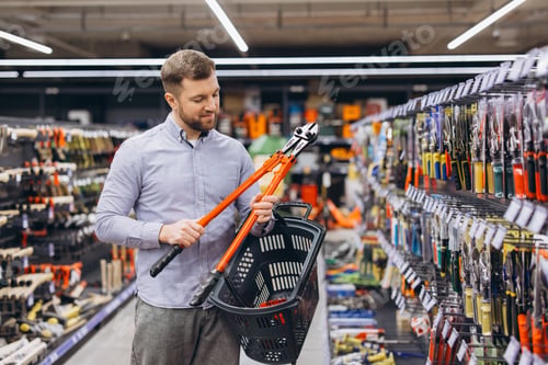 Preview: Man shopping for tools in a hardware store, holding a large bolt cutter