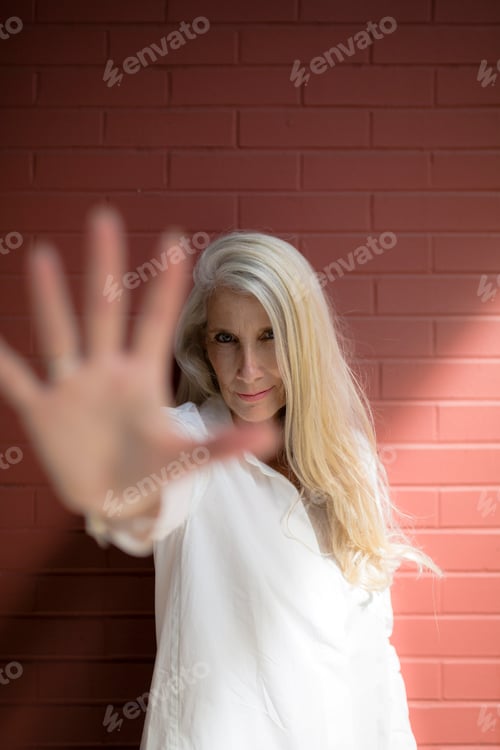 Preview: Portrait of mature woman raising her hand