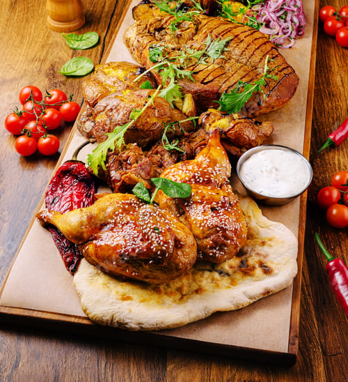 Preview: Grilled meat platter with fresh herbs and vibrant garnishes at a cozy spot