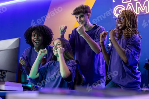 Preview: group of young eSports team playing video games on computer celebrate winning
