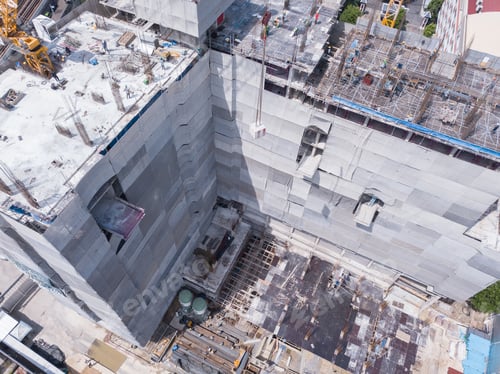 Preview: Aerial view of busy industrial construction site workers working. Development high rise building.