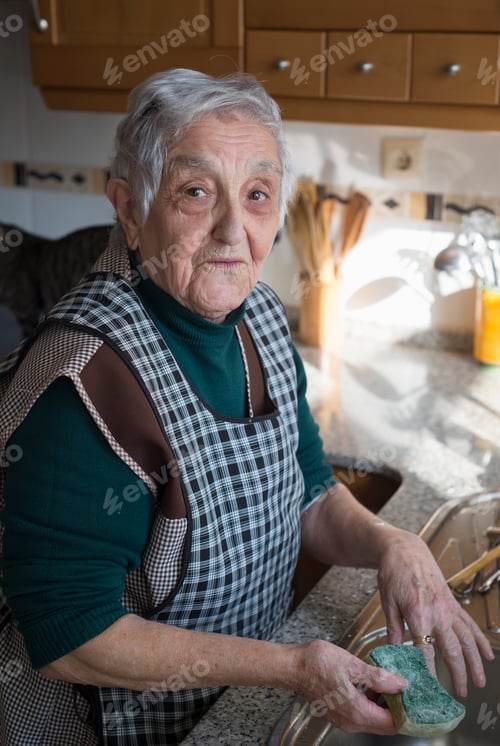 Preview: Portrait of senior woman washing dishes in the kitchen