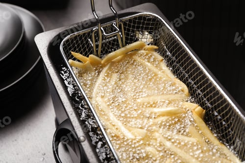 Preview: Cooking delicious french fries in hot oil, closeup