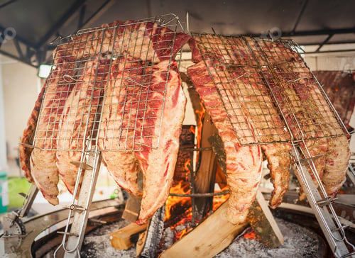 Preview: Roasted meat of beef cooked on a vertical grills.