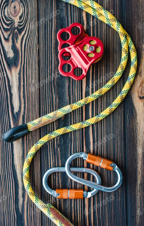 Preview: Isolated photo of climbing equipment. Parts of carabiners lying on the wooden table