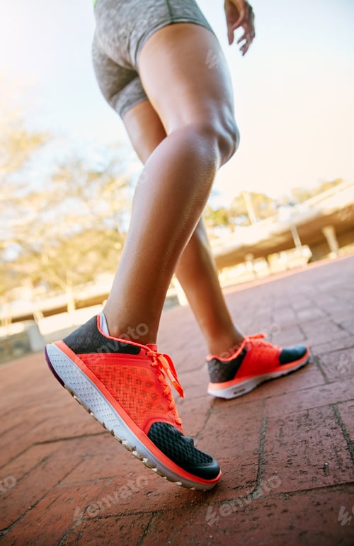 Preview: Low angle shot of an unrecognizable athletic woman out for a run in the city