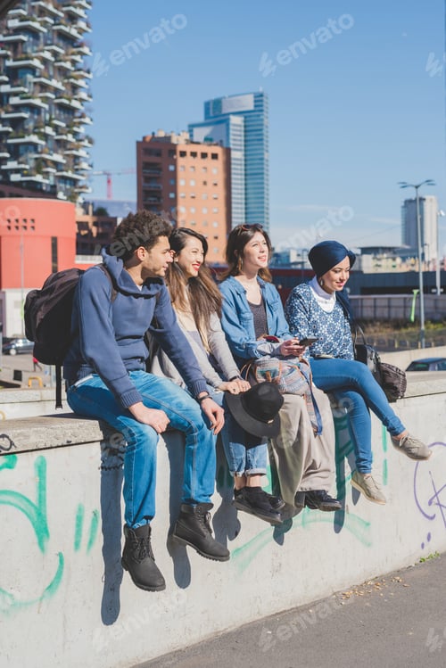 Preview: Multiracial group young people sitting outdoor chatting