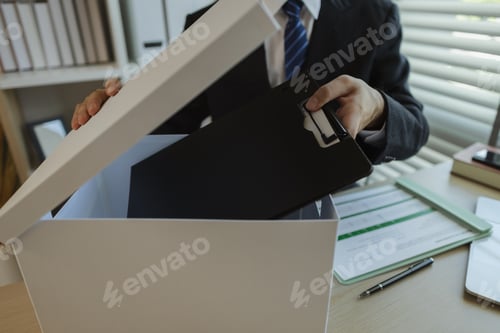 Preview: An office worker is putting important documents in boxes to prevent loss. A businessman is putting i