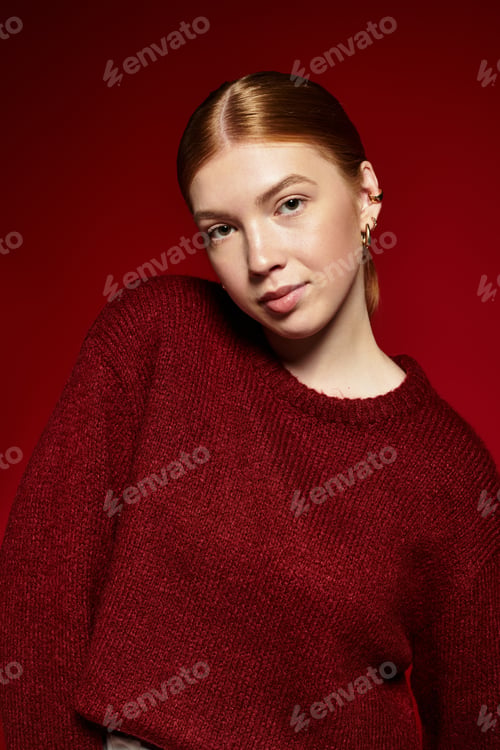 Preview: Red-haired young woman showcases winter fashion against a vibrant background