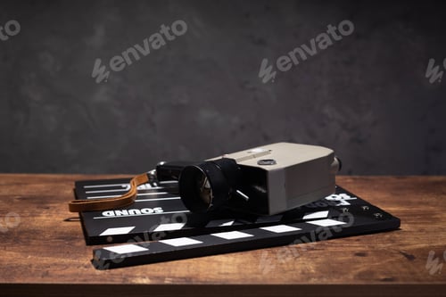 Preview: movie clapper board and film retro camera at table