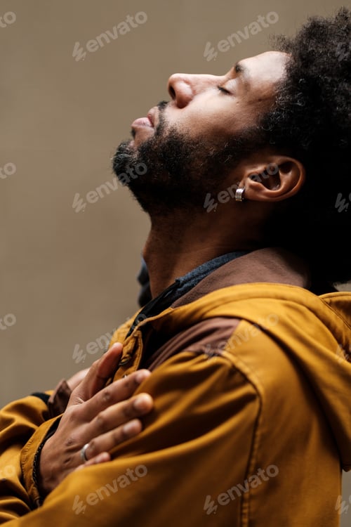 Preview: Young man praying with closed eyes and head up