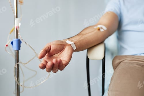 Preview: Male arm with IV drip infusion in treatment session at clinic