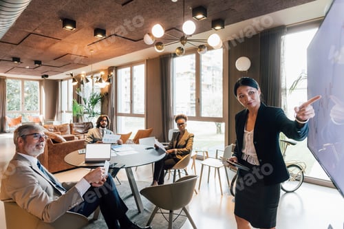Preview: Confident professional presenting to colleagues in a modern office space.