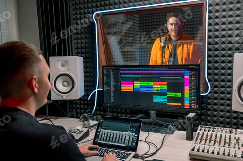 Preview: artist recording a new song in recording studio sound engineer watching tracks on display