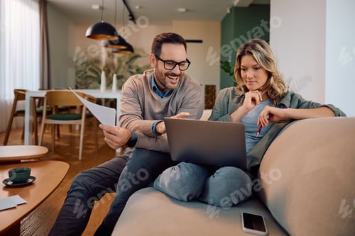 Preview: Couple Smiling and Looking at Laptop in Home