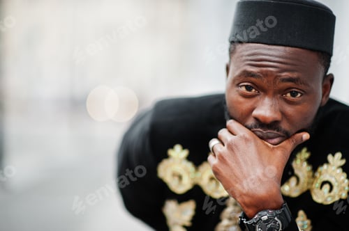 Preview: Mega stylish african man in traditional jacket pose. Fashionable black guy in hat.