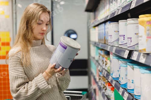 Preview: Woman buys infant milk formula at supermarket, portrait of young mother in shop mall