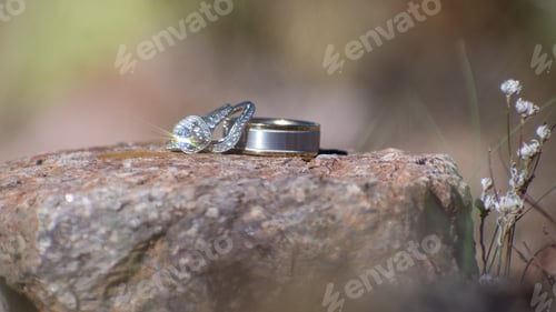 Preview: Closeup shot of wedding rings on a rock surface against a blurred background