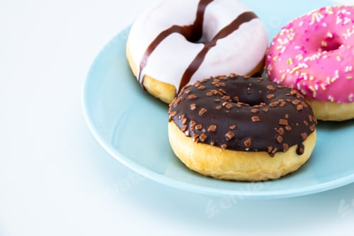 Preview: Closeup of three delicious donuts on a ceramic plate in front of an isolated white background