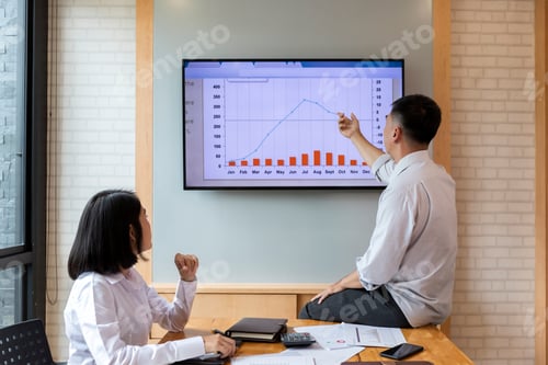 Preview: Businessman present the monthly college budget in front of TV to his colleagues during meeting