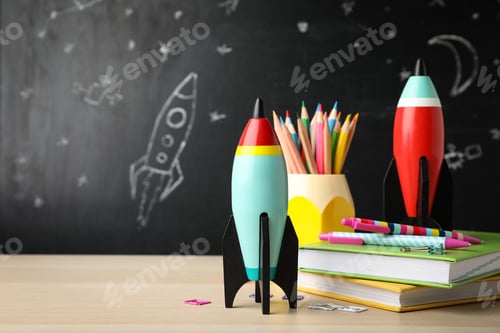 Preview: Bright toy rockets and school supplies on wooden table