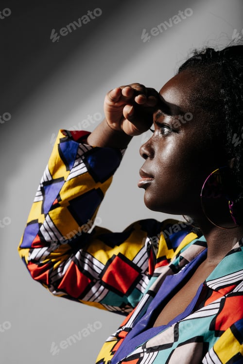 Preview: Black woman in colorful clothes looking away