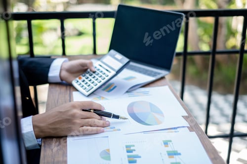 Preview: Young businessman financial market analyst sits at their desks and calculate financial graphs