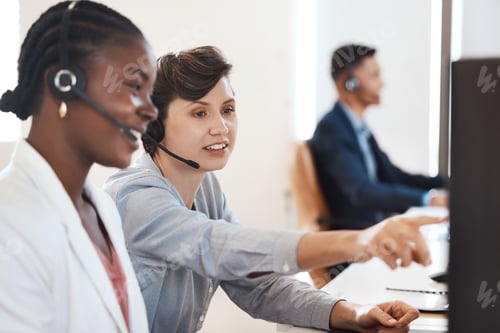 Preview: Shot of two call centre agents working together on a computer in an office